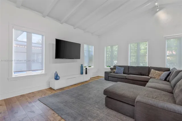 a view of a dining room with furniture a chandelier and wooden floor