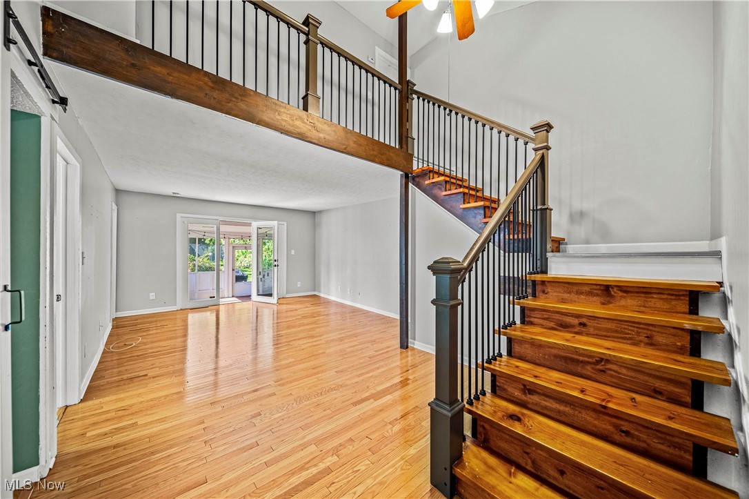 1796 Lander Road Mayfield Heights, OH 44124 - Photo 13 of 39 Stairway featuring a barn door, ceiling fan, and hardwood / wood-style flooring