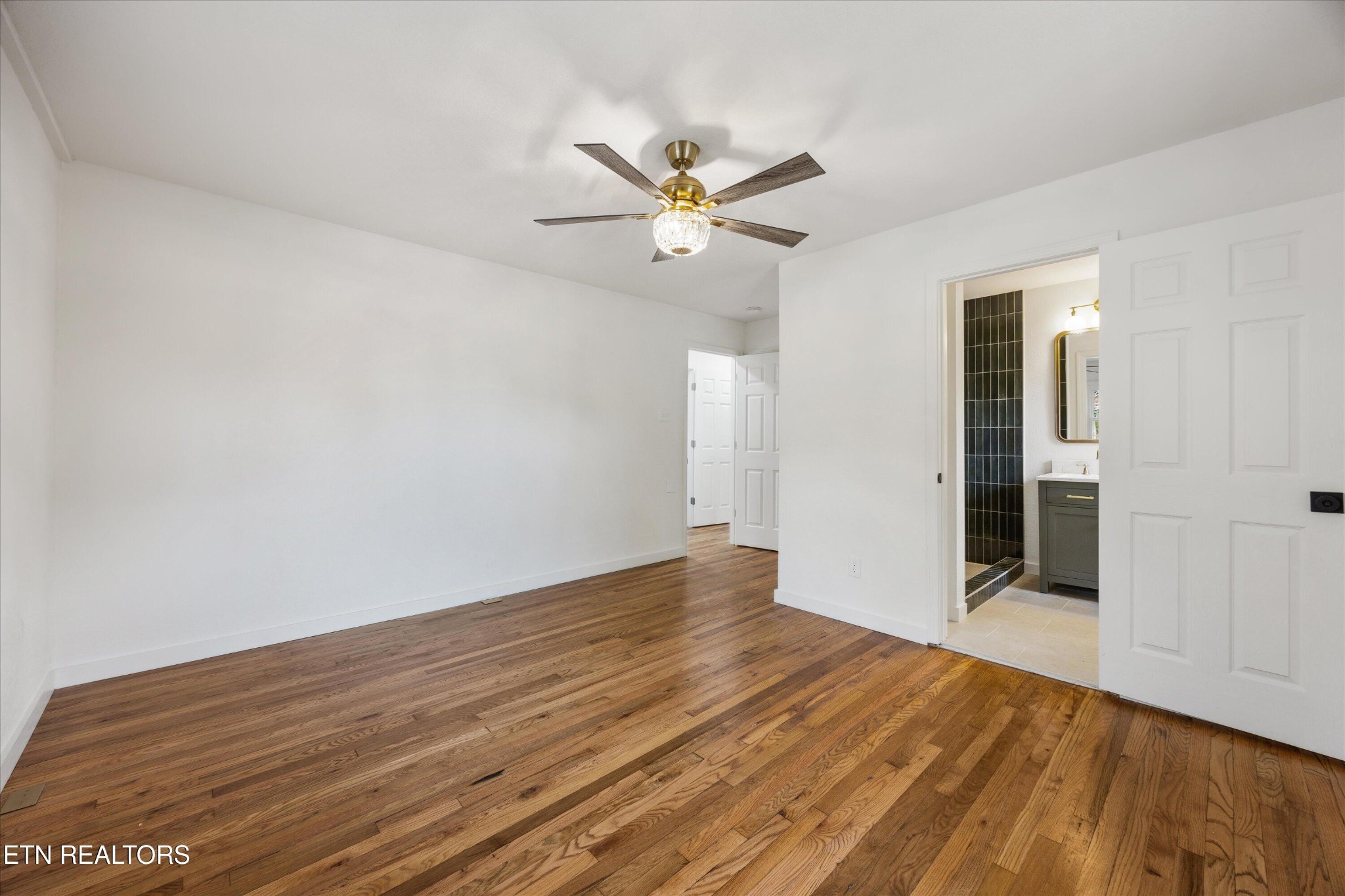 100 Pearl Road Oak Ridge, TN 37830 - Photo 18 of 37 an empty room with wooden floor fan and windows