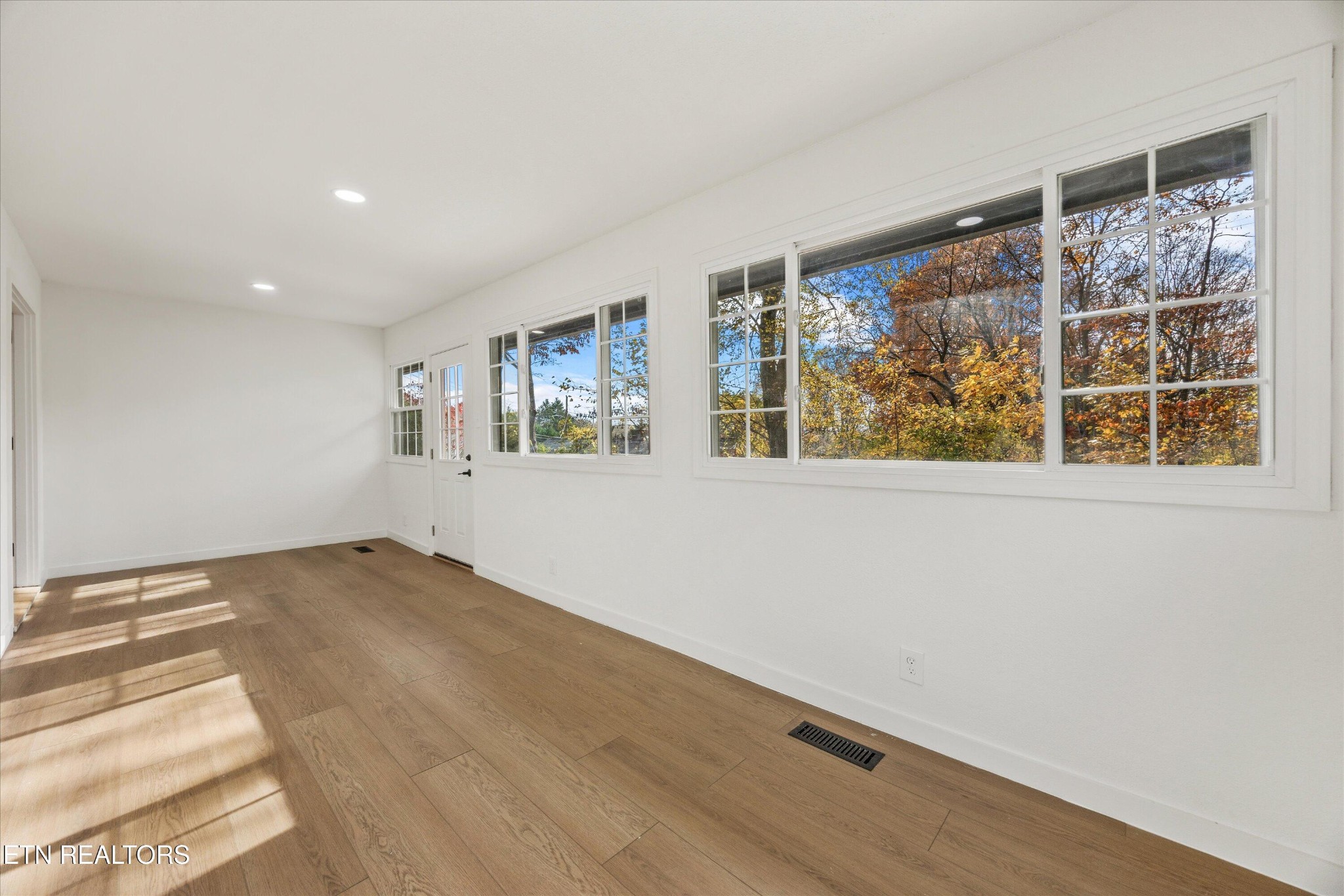 100 Pearl Road Oak Ridge, TN 37830 - Photo 29 of 37 a view of an empty room with a window and wooden floor