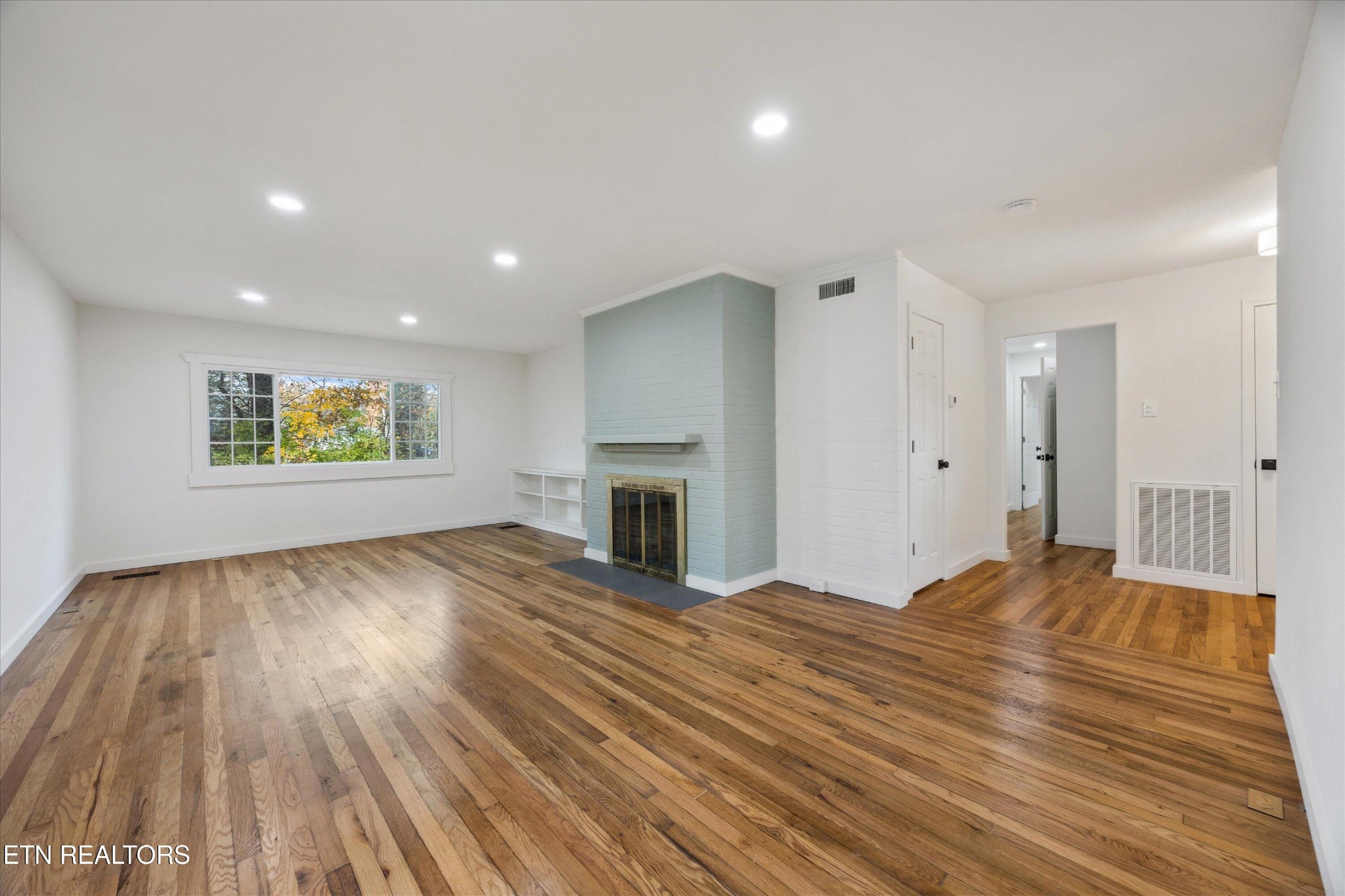 100 Pearl Road Oak Ridge, TN 37830 - Photo 7 of 37 a view of empty room with wooden floor and fireplace
