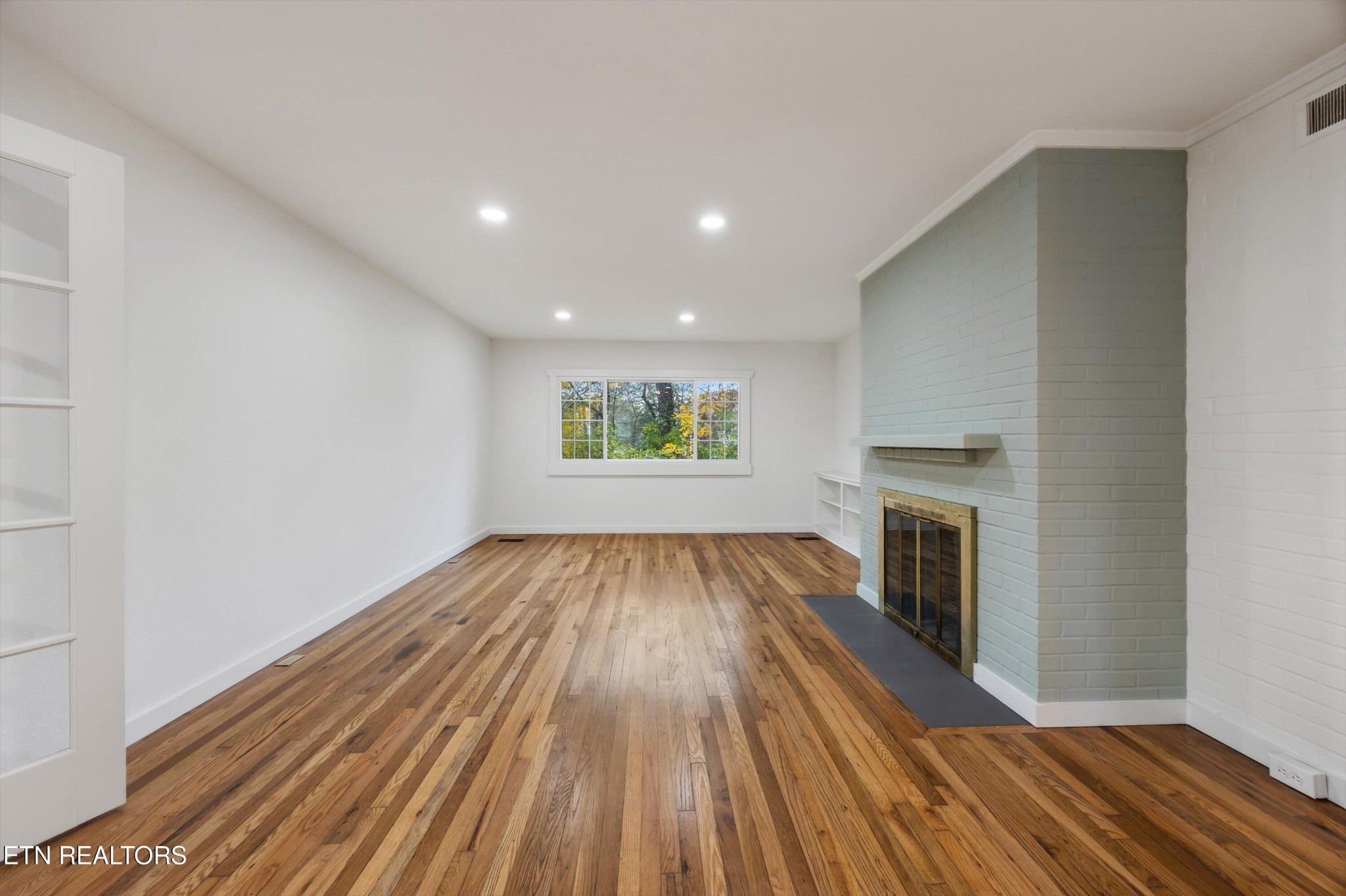 100 Pearl Road Oak Ridge, TN 37830 - Photo 9 of 37 a view of empty room with a fireplace and wooden floor