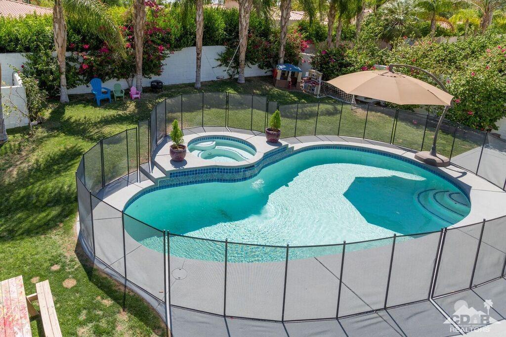 a view of a backyard with table and chairs under an umbrella