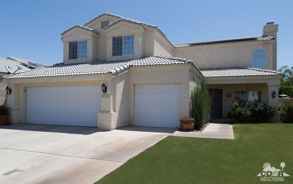 41310 Carlotta Drive Palm Desert, CA 92211 - Photo 2 of 32 a front view of a house with a yard