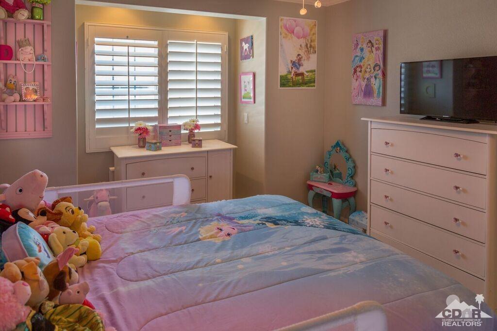 41310 Carlotta Drive Palm Desert, CA 92211 - Photo 23 of 32 a bedroom with a bed and flat screen tv