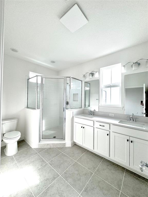 4826 Prairie Preserve Run St. Cloud, FL 34772 - Photo 19 of 44 a spacious bathroom with a granite countertop sink a toilet and a bathtub