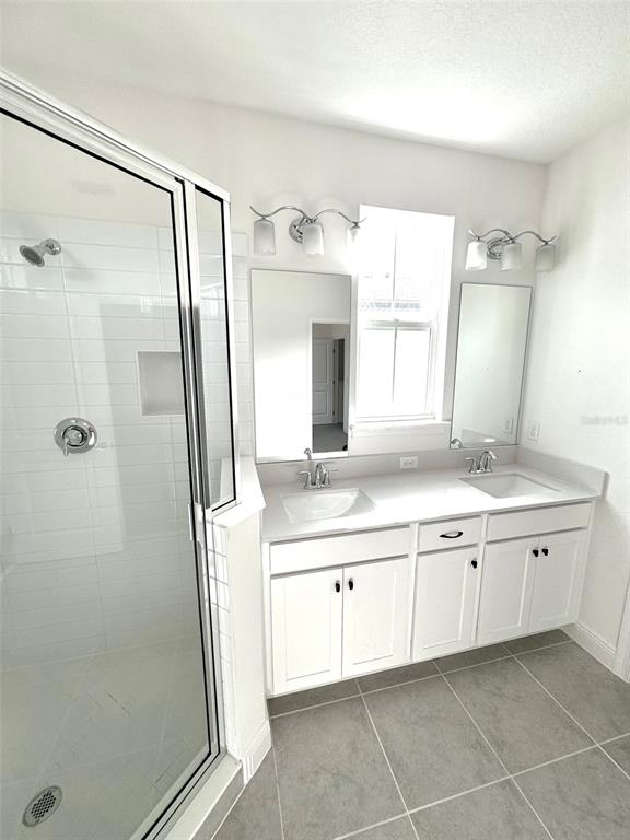 4826 Prairie Preserve Run St. Cloud, FL 34772 - Photo 21 of 44 a bathroom with a granite countertop sink mirror and a bathtub
