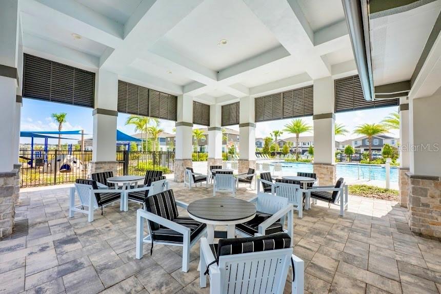4826 Prairie Preserve Run St. Cloud, FL 34772 - Photo 43 of 44 a living room with couches a flat screen tv and kitchen view
