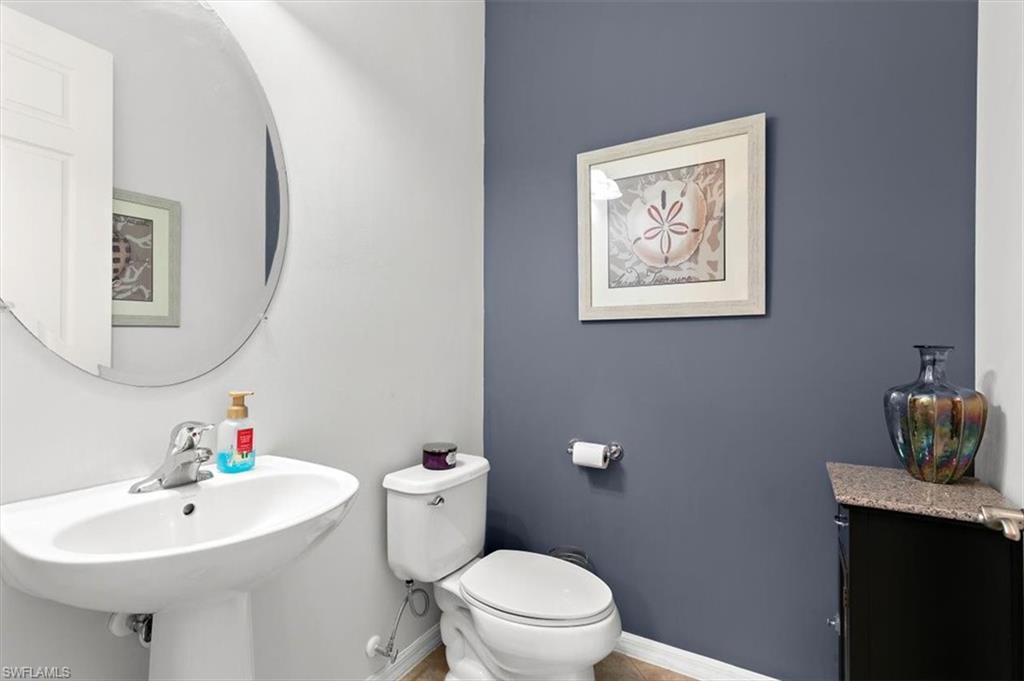 8985 Cambria Circle, Unit 211 Naples, FL 34113 - Photo 13 of 41 a bathroom with a toilet a sink and mirror