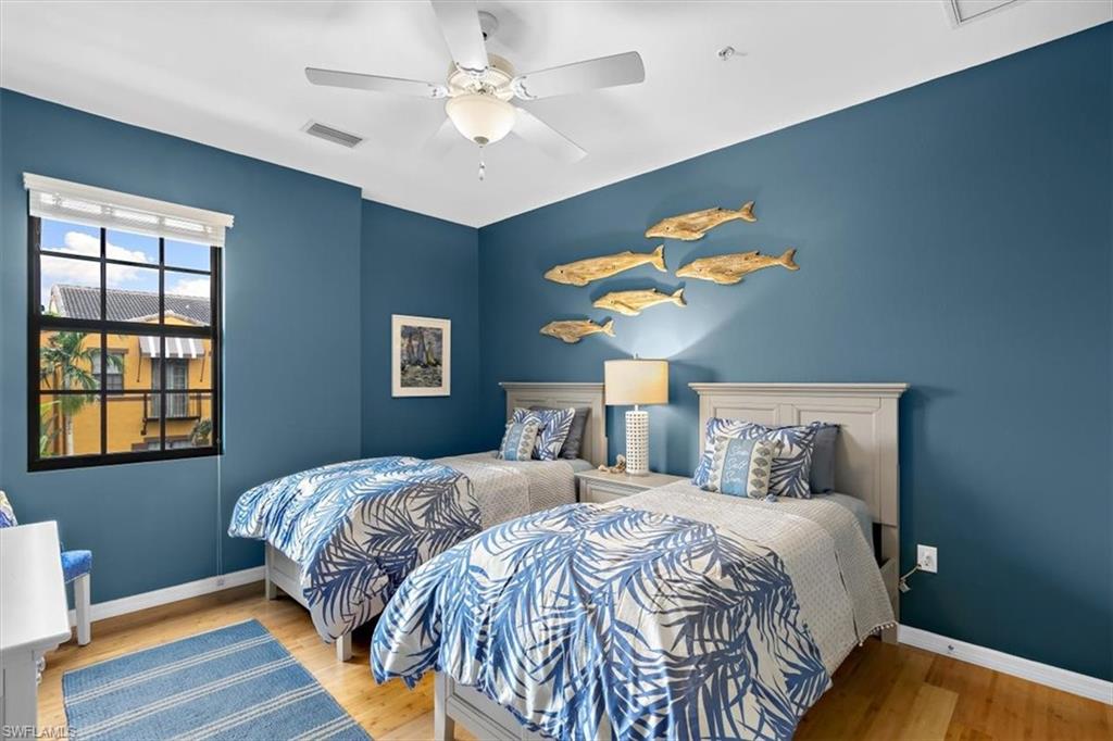 8985 Cambria Circle, Unit 211 Naples, FL 34113 - Photo 14 of 41 a bedroom with a bed and a chandelier