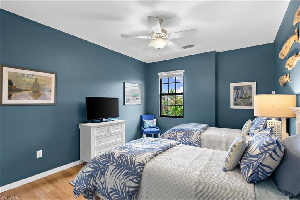 8985 Cambria Circle, Unit 211 Naples, FL 34113 - Photo 15 of 41 a bedroom with a bed and a flat screen tv