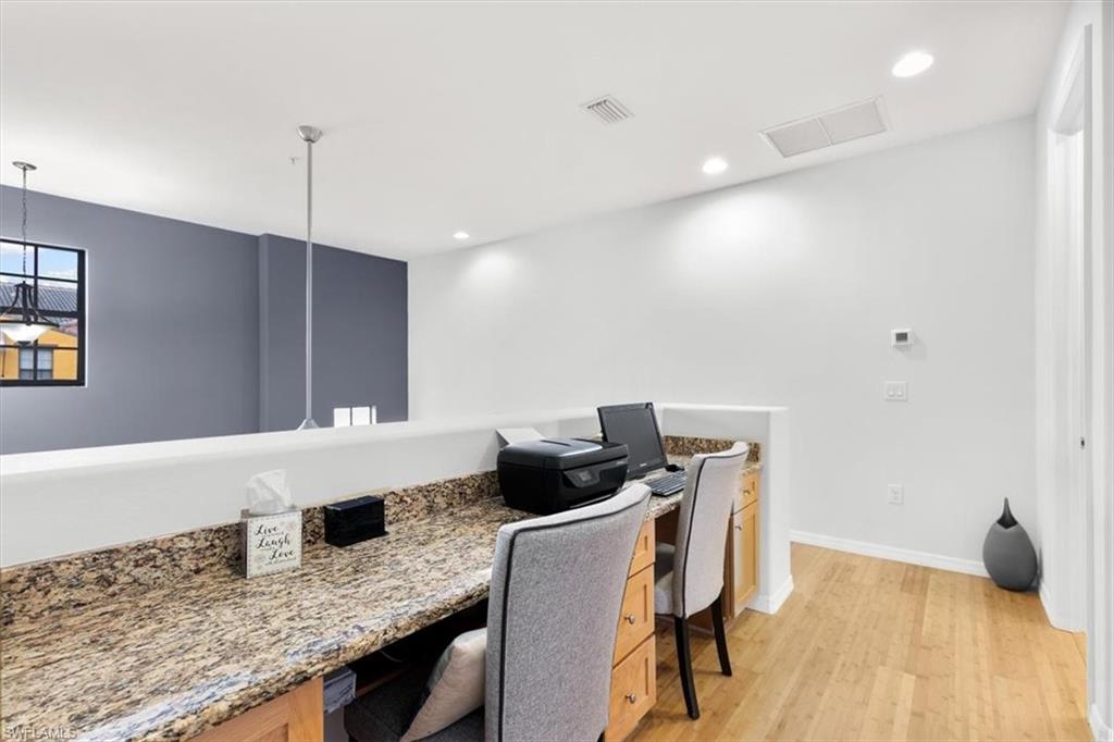 8985 Cambria Circle, Unit 211 Naples, FL 34113 - Photo 20 of 41 a kitchen with granite countertop cabinets and chairs