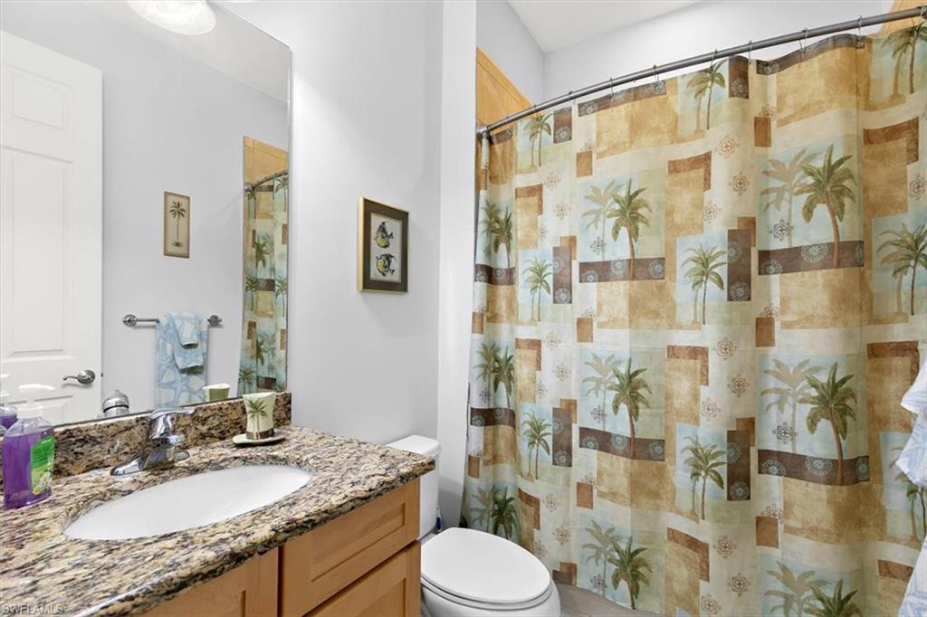 8985 Cambria Circle, Unit 211 Naples, FL 34113 - Photo 21 of 41 a bathroom with a granite countertop sink a toilet and shower
