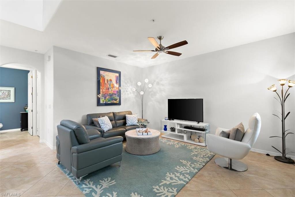 8985 Cambria Circle, Unit 211 Naples, FL 34113 - Photo 3 of 41 a living room with furniture and a flat screen tv