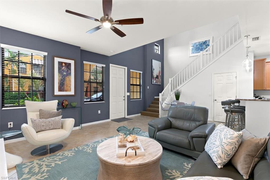 8985 Cambria Circle, Unit 211 Naples, FL 34113 - Photo 5 of 41 a living room with furniture a fireplace and a chandelier