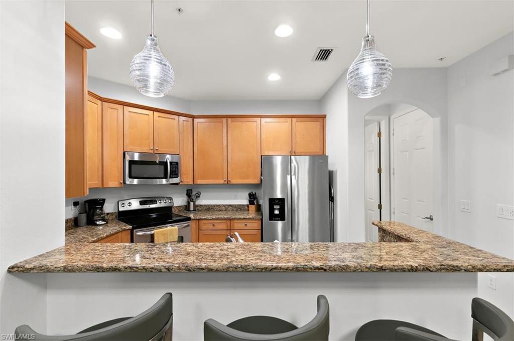 8985 Cambria Circle, Unit 211 Naples, FL 34113 - Photo 9 of 41 a kitchen with stainless steel appliances granite countertop a sink refrigerator and microwave
