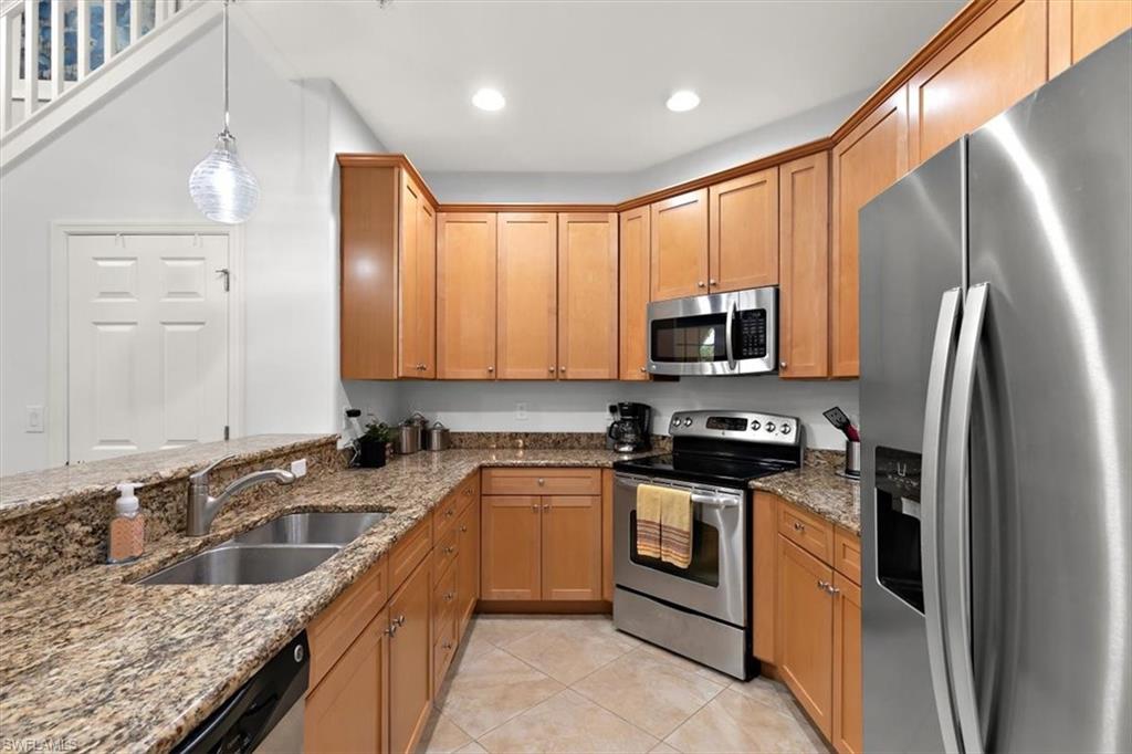 8985 Cambria Circle, Unit 211 Naples, FL 34113 - Photo 10 of 41 a kitchen with a sink stove and refrigerator