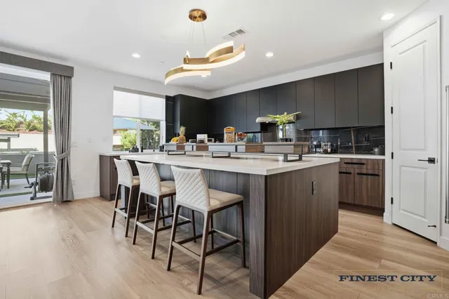 a living room with stainless steel appliances kitchen island granite countertop a table and chairs