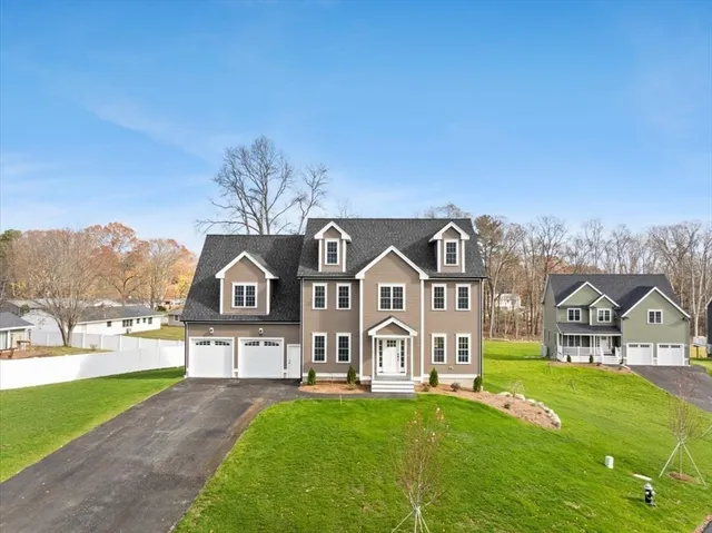 a view of a big house with a big yard and large trees
