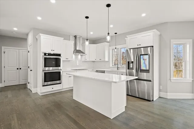 a large kitchen with stainless steel appliances kitchen island granite countertop a stove a sink and a refrigerator