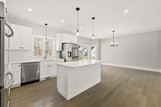 a large kitchen with kitchen island a white counter space a sink and appliances