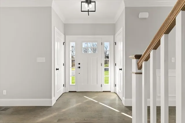 a view of a hallway with wooden floor and staircase