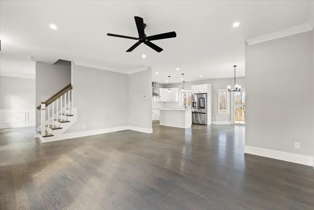 a view of a livingroom with a ceiling fan & wooden floor