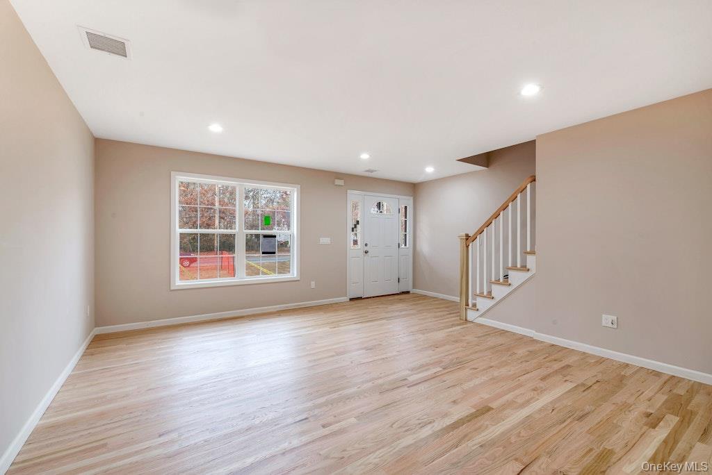 514 Neighborhood Road Shirley, NY 11967 - Photo 6 of 20 a view of an empty room with wooden floor and a window