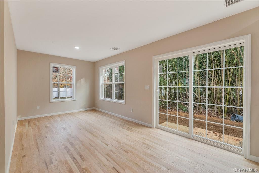 514 Neighborhood Road Shirley, NY 11967 - Photo 7 of 20 a view of empty room with wooden floor and windows