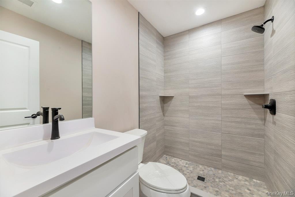 514 Neighborhood Road Shirley, NY 11967 - Photo 8 of 20 a bathroom with a sink a toilet and shower