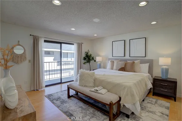 a spacious bedroom with a bed a couch and dresser