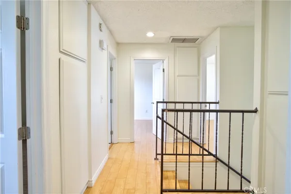 a view of a hallway with wooden floor and staircase