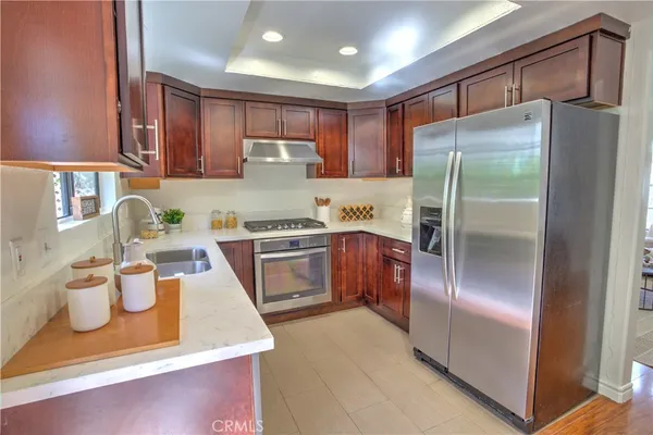 a kitchen with stainless steel appliances granite countertop a refrigerator a stove and a sink
