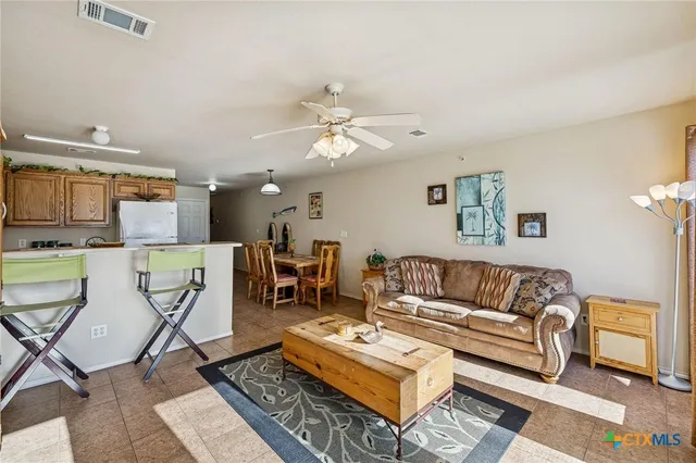 a living room with furniture a rug and kitchen view