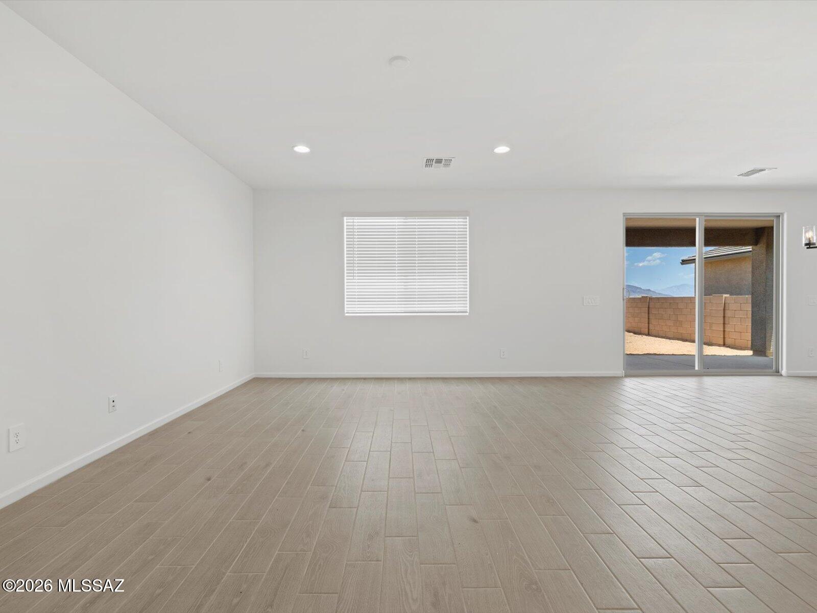 5133 West Gainer Ridge Road Tucson, AZ 85757 - Photo 5 of 16 an empty room with wooden floor and windows