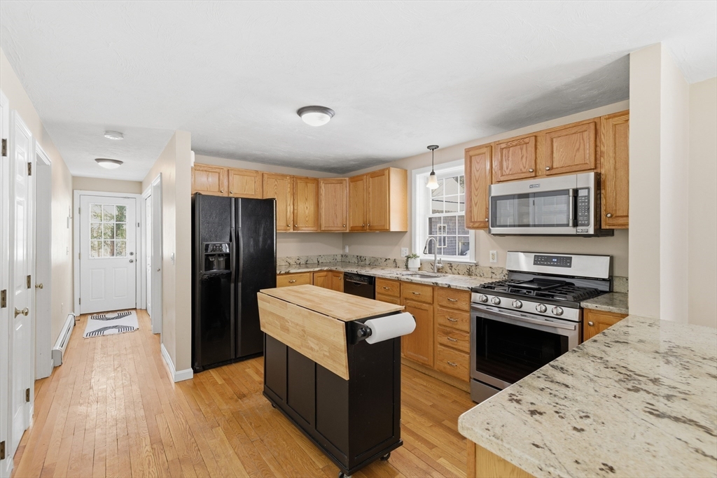 318 Old Mill Road Barnstable, MA 02648 - Photo 11 of 36 a kitchen with a refrigerator a sink and wooden cabinets