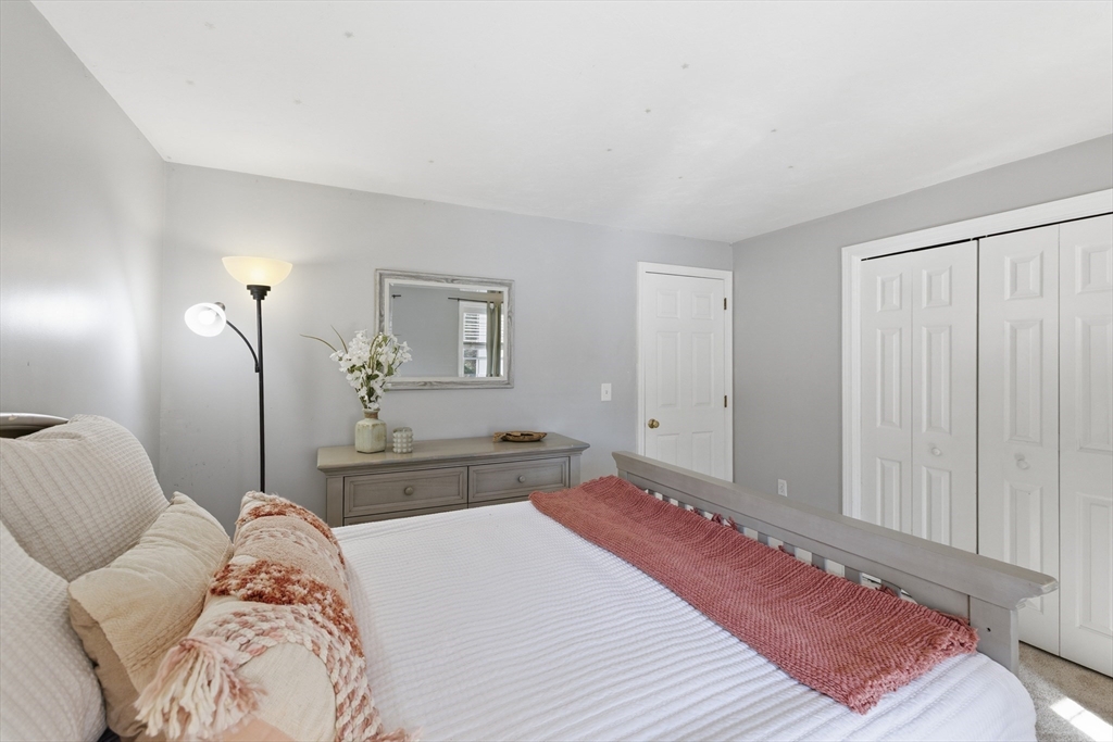 318 Old Mill Road Barnstable, MA 02648 - Photo 15 of 36 a bedroom with a large bed and a chandelier
