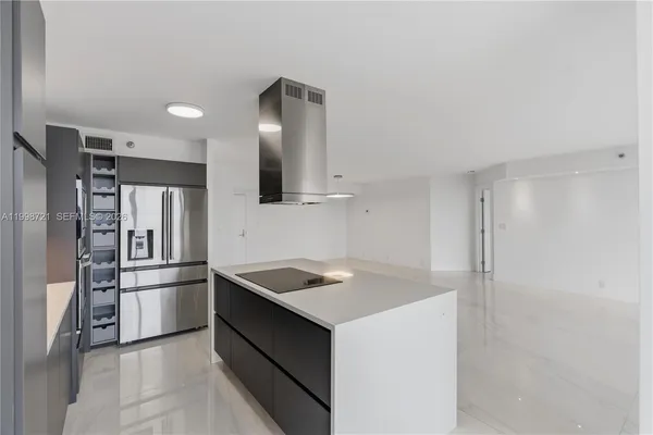 a kitchen with a sink a refrigerator and a stove top oven