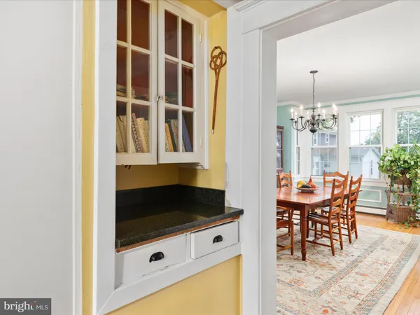 a kitchen that has a lot of white cabinets and wooden floor