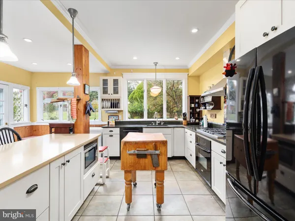 a living room with stainless steel appliances kitchen island granite countertop furniture and a fireplace