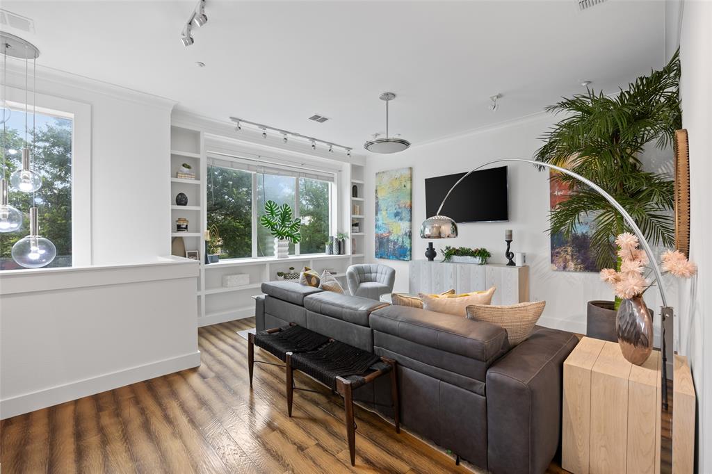 4312 McKinney Avenue, Unit 4 Dallas, TX 75205 - Photo 4 of 34 Living area with track lighting, wood finished floors, built in shelves, plenty of natural light, and crown molding