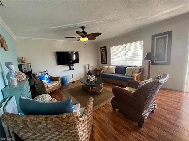 a living room with furniture a flat screen tv and a window