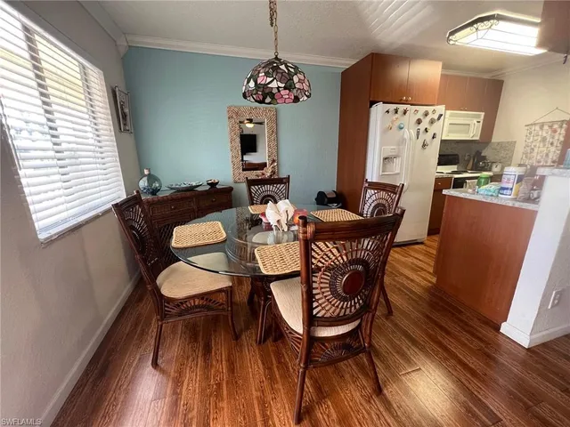 a dining room with furniture a chandelier and wooden floor