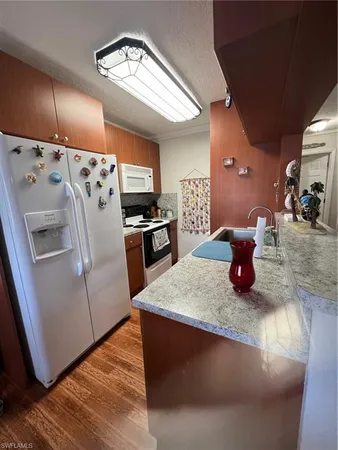 a kitchen with stainless steel appliances granite countertop a sink a stove and a refrigerator