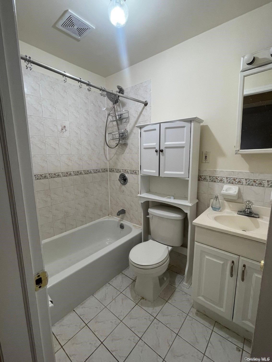 88-10 78th Street Queens, NY 11421 - Photo 5 of 12 Full bath with shower / bath combination with curtain, vanity, and tile walls