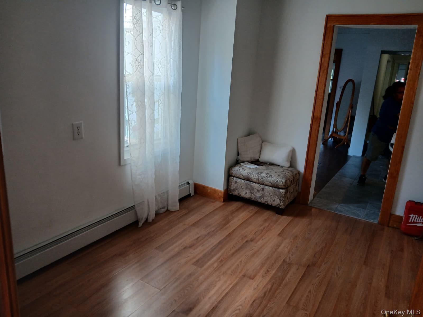 88-10 78th Street Queens, NY 11421 - Photo 9 of 12 Sitting room featuring a baseboard heating unit and wood finished floors