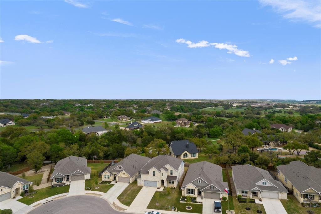 236 Prato Place Georgetown, TX 78628 - Photo 3 of 40 An aerial perspective reveals a vibrant neighborhood nestled among verdant trees and sprawling green landscapes.