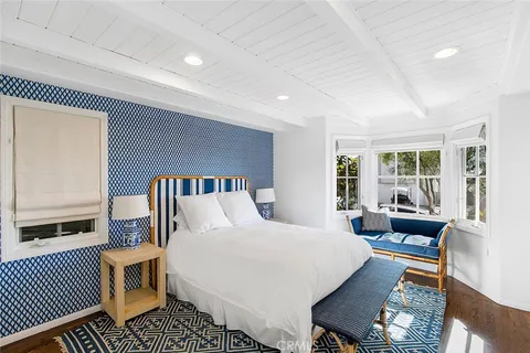 a bedroom with furniture and a large window