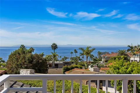 a view of a city with flower plants and wooden fence
