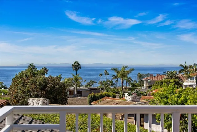 a view of a city with flower plants and wooden fence